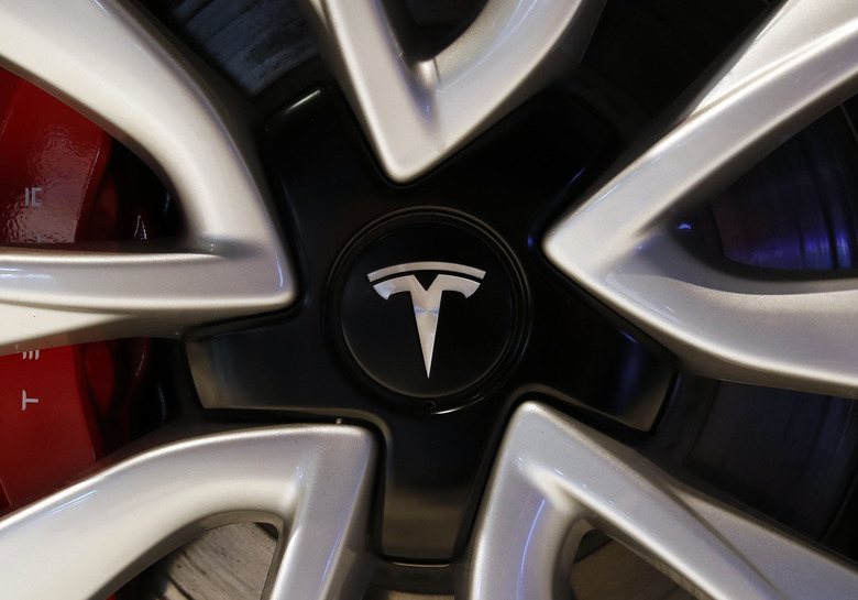 The logo of Tesla model 3 is pictured at the Auto show in Paris, France, Wednesday, Oct. 3, 2018, 2018. All-electric vehicles with zero local emissions are among the stars of the Paris auto show, rubbing shoulders with the fossil-fuel burning SUVs that many car buyers love. (AP Photo/Christophe Ena)