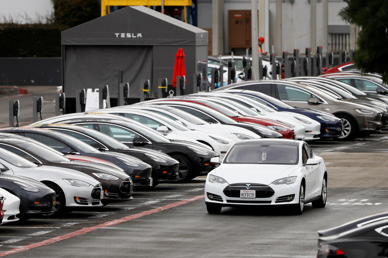 A Tesla Model S electric vehicle drives along a row of occupied superchargers at Tesla's primary vehicle factory after CEO Elon Musk announced he was defying local officials' restrictions against the coronavirus disease (COVID-19) by reopening the plant in Fremont, California, U.S. May 12, 2020. REUTERS/Stephen Lam