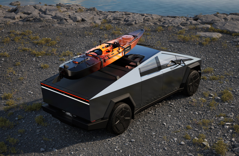 A silver vehicle with a canoe on its roof. 