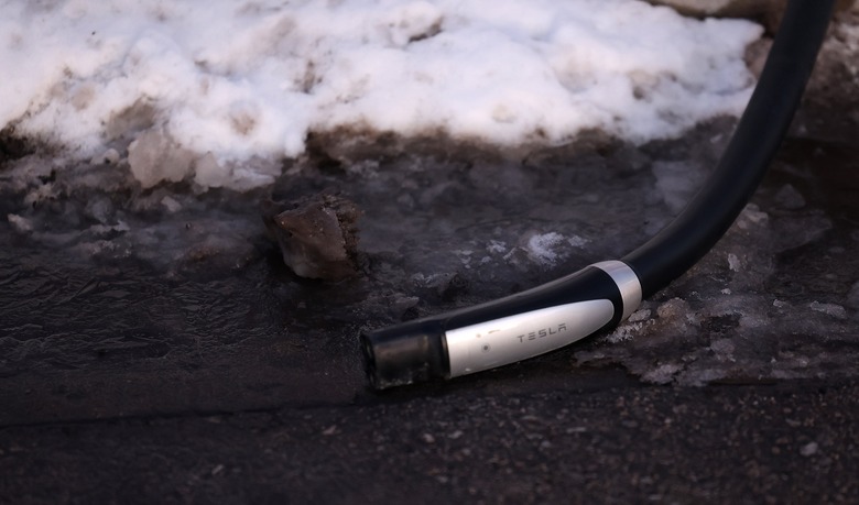 MACKINAC, MI - JANUARY 20  -   Marco Chown Oved charges the rental Tesla at the Tesla super chargers near the Mackinac Island Ferry depot  in Mackinac. January 20, 2024.    Steve Russell/Toronto Star        (Steve Russell/Toronto Star via Getty Images)