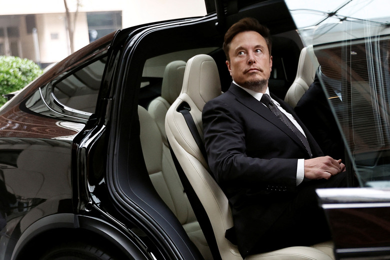 Tesla Chief Executive Officer Elon Musk gets in a Tesla car as he leaves a hotel in Beijing, China May 31, 2023. REUTERS/Tingshu Wang/File Photo