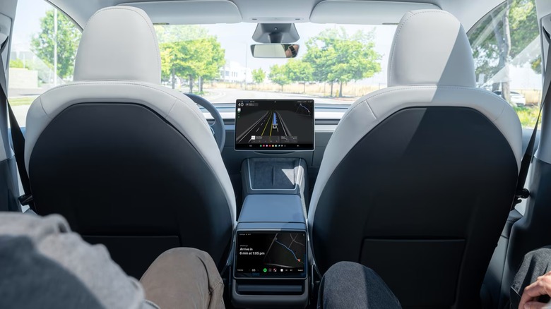 The inside view of a Tesla Robotaxi, specifically from the backseat.