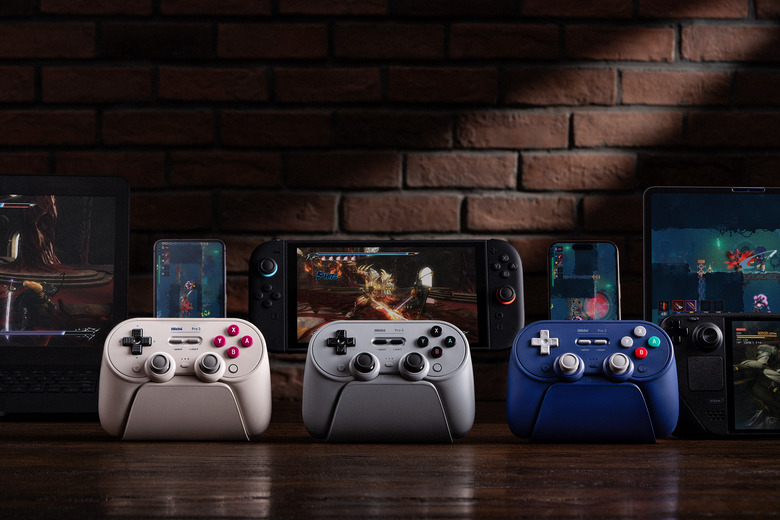 Promo image showing the white, gray and purple models of the 8BitDo Pro 3 controller. 