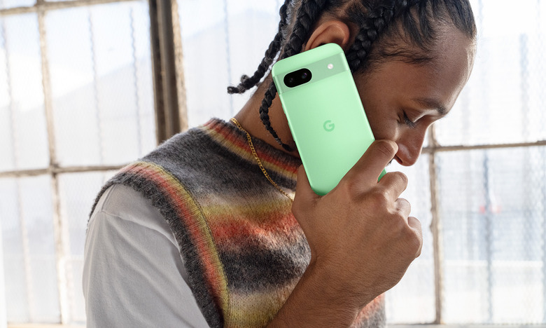 A person holds the new Pixel 8a in the Aloe colorway.