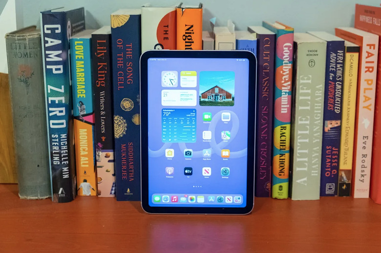 A tablet in front of books.