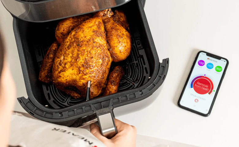 Meater Plus smart thermometer used to check internal heat of a chicken.