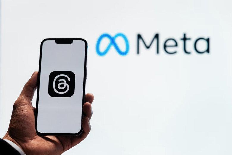 Logo on a phone with Meta sign in background.