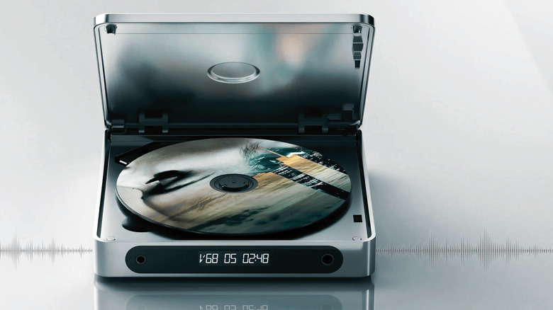 Product marketing image of the FiiO DM13 portable CD player. It sits open with a CD inside. Waveform background.