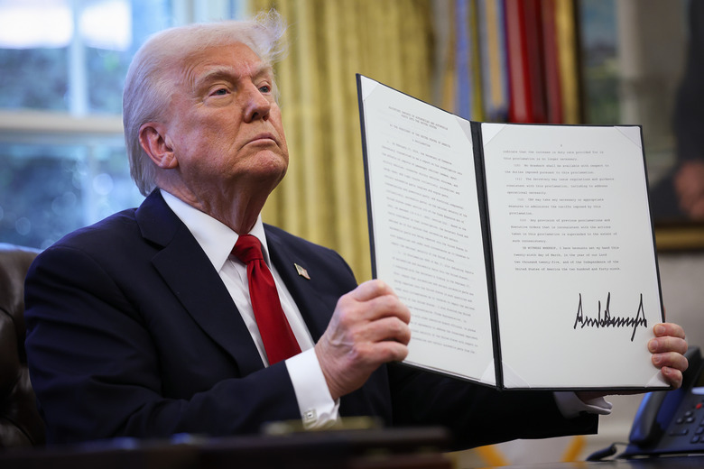 WASHINGTON, DC - MARCH 26: U.S. President Donald Trump displays a signed an executive order in the Oval Office of the White House on March 26, 2025 in Washington, DC. President Trump announced 25% tariffs on all foreign-made cars.  (Photo by Win McNamee/Getty Images)