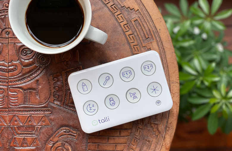 An overhead view of the Talli Baby tracker and a cup of coffee on a small round table.