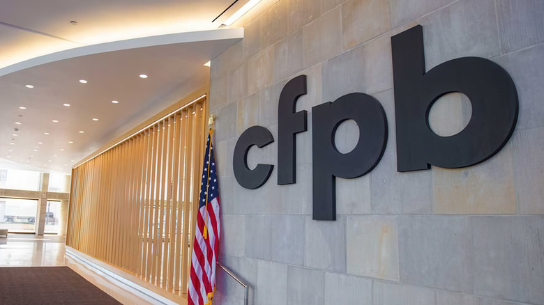 A CFPB logo and American flag inside a government building.