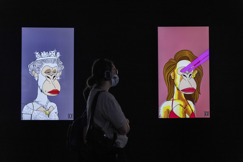 A visitor looks at NFT (non-fungible tokens - blockchain tokens) works featured in Tomorrow, a digital multimedia exhibition at Ramat Gan stadium in Israel, Wednesday, Aug. 24, 2022. The exhibition combines the works of Claude Monet, Wassily Kandinsky, Paul Cézanne, Vincent van Gogh, Gustav Klimt, Aubrey Beardsley among others with digital, multimedia art from the NFT and Virtual Reality realms, closes on Oct. 17. (AP Photo/Tsafrir Abayov)