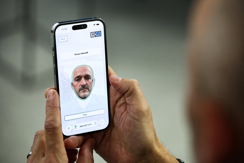 This photo taken on October 14, 2025 shows Chris Fields, CMO of AI-powered age verification start-up Yoti, giving a demonstration of the company's age verification technology at their offices in London. As governments crack down on online platforms from social networks to porn sites, business is booming for a specialist sector offering AI age checks based on selfies. (Photo by HENRY NICHOLLS / AFP via Getty Images) 