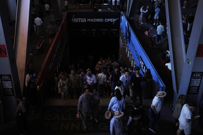 Spectators roam inside the Madrid Open tennis tournament venue during a general blackout in Madrid, Monday, April 28, 2025. (AP Photo/Manu Fernandez)