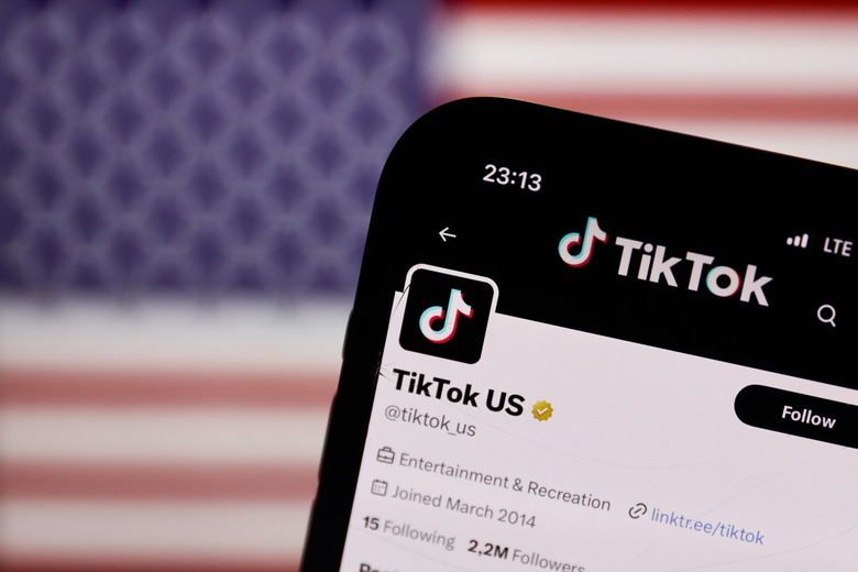 TikTok US account on X displayed on a phone screen is seen with American flag displayed on a screen in the background in this illustration photo taken in Krakow, Poland on April 24, 2024. (Photo by Jakub Porzycki/NurPhoto via Getty Images)