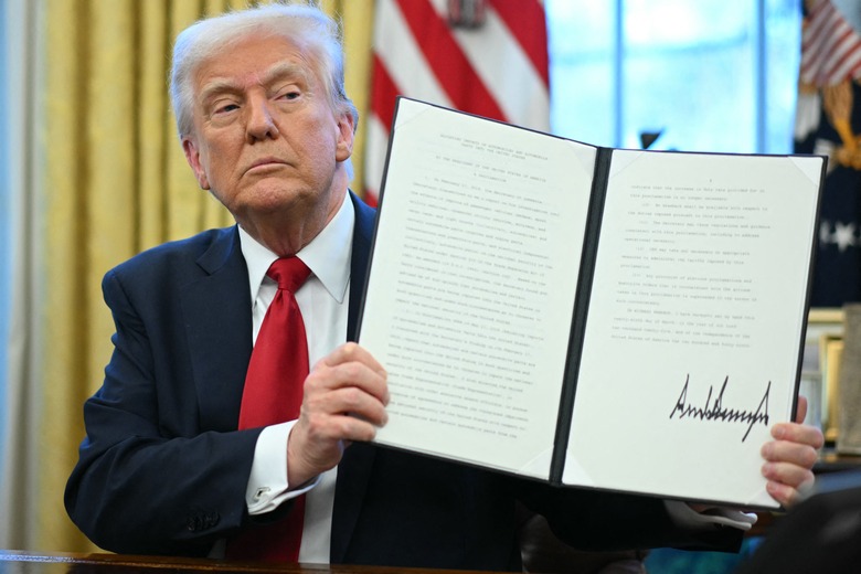 US President Donald Trump displays an executive order he signed announcing tariffs on auto imports in the Oval Office of the White House in Washington, DC, on March 26, 2025. Trump announced imposition of 25 percent tariffs on all cars and light trucks not built on US soil. 