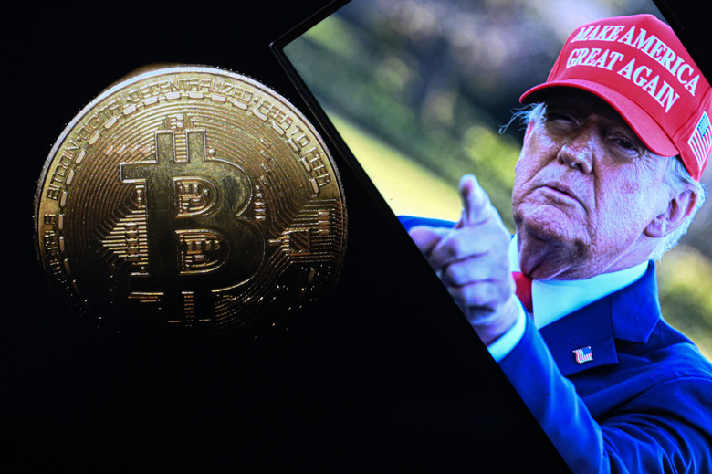 ANKARA, TURKIYE - MARCH 07: In this photo illustration, a 'Bitcoin' coin is displayed on mobile phone screen in front of the US President Donald J. Trump's photo in Ankara, Turkiye on March 07, 2025. (Photo by Harun Ozalp/Anadolu via Getty Images)
