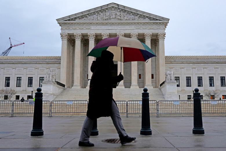 A person walks in front of the U.S. Supreme Court building during rainy weather, in Washington, U.S. January 17, 2023.  