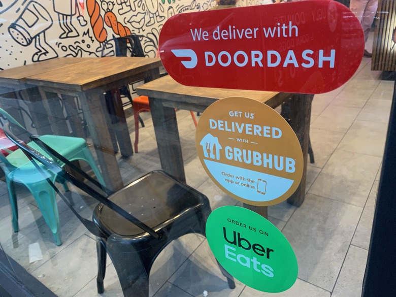We Deliver, Doordash, Grubhub and Uber Eats signs on restaurant door, New York City. (Photo by: Lindsey Nicholson/UCG/Universal Images Group via Getty Images)