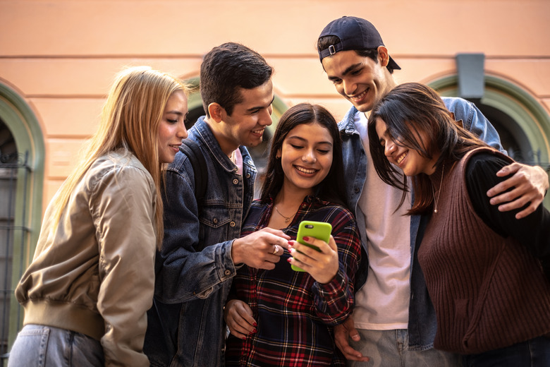 Teenager friends using the mobile phone outdoors