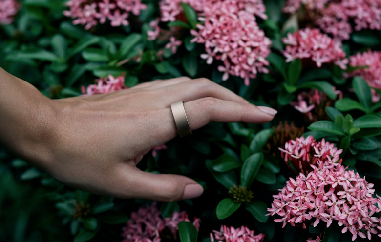 A ring on a finger amongst flowers.