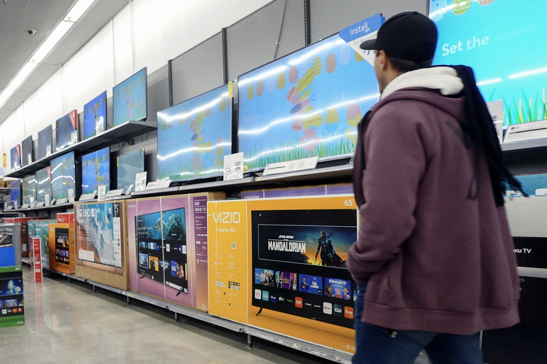 HALLANDALE BEACH, FLORIDA - FEBRUARY 20: A customer walks past televisions, including the Vizio brand, on display in a Walmart Supercenter on February 20, 2024, in Hallandale Beach, Florida. Walmart reported that quarterly revenue rose 6%, and that the company’s global e-commerce sales have also grown. Walmart also said that it agreed to purchase TV maker Vizio for $2.3 billion. (Photo by Joe Raedle/Getty Images)