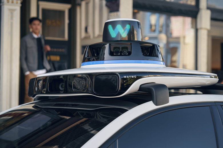 A car with Waymo equipment on top.                               