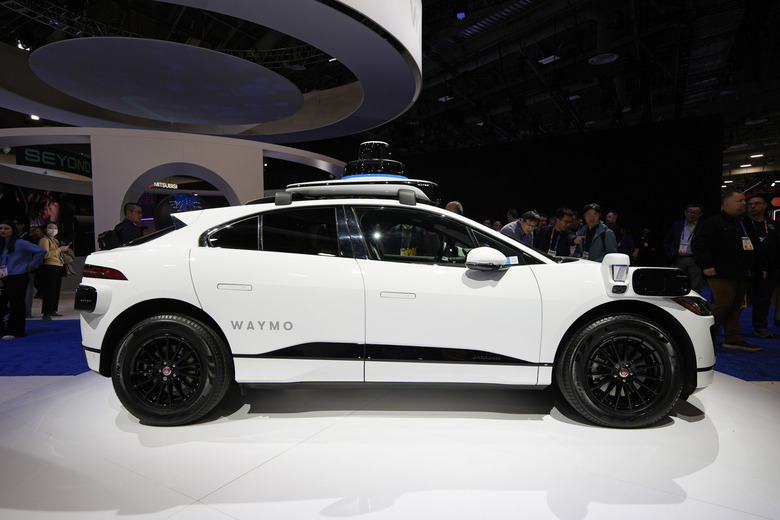 People look at a Jaguar I-Pace with 5th Generation Waymo Driver on display at the Waymo booth during the CES tech show Tuesday, Jan. 7, 2025, in Las Vegas. (AP Photo/John Locher)
