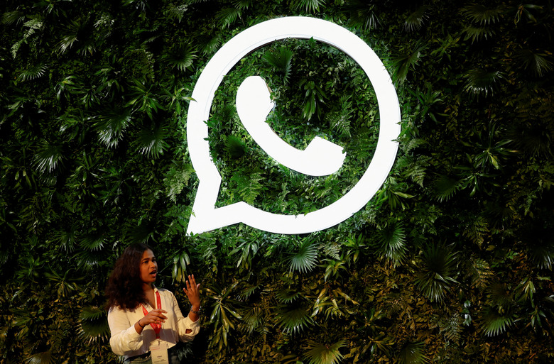 FILE PHOTO: A woman stands next to a logo of messaging application Whatsapp during a Meta conference in Mumbai, India, September 20, 2023. REUTERS/Francis Mascarenhas/File Photo