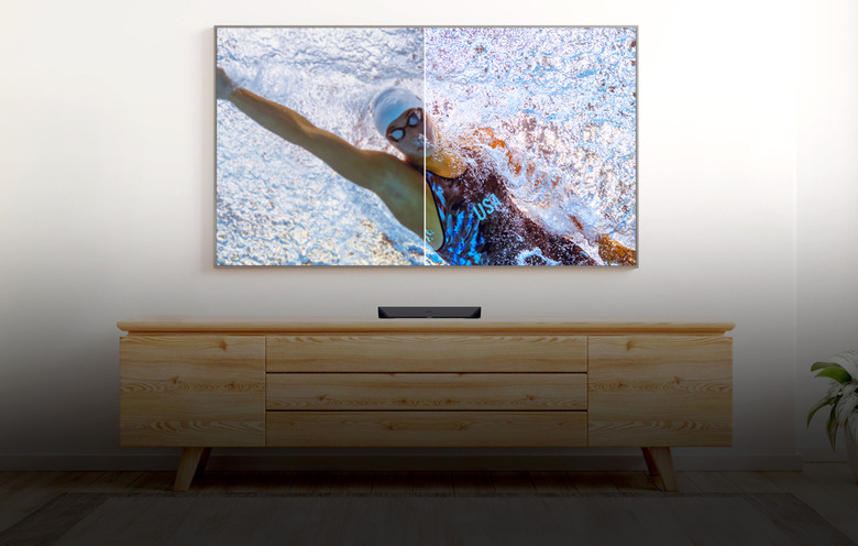 A TV showing a swimmer right above a console.