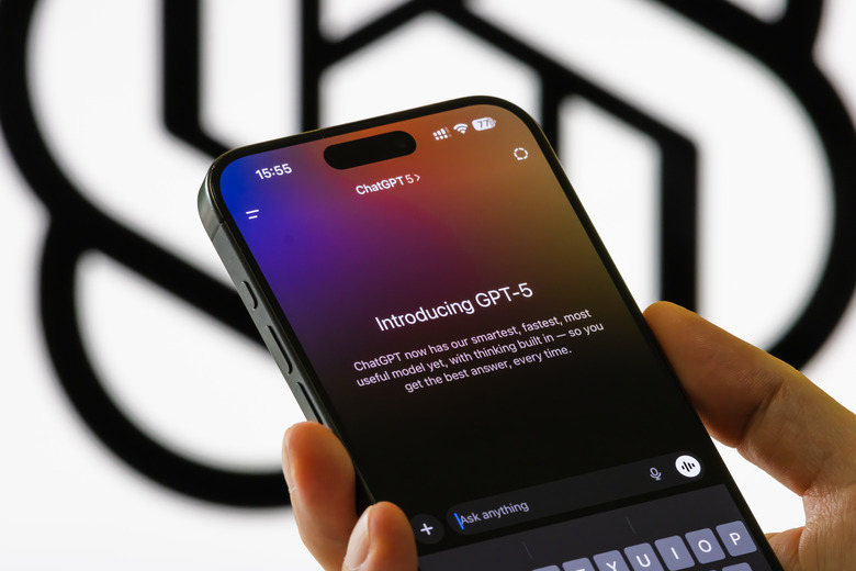 CHONGQING, CHINA - AUGUST 9: In this photo illustration, a person holds a smartphone showing the Introducing GPT-5 interface in the ChatGPT app, with text describing the model's capabilities, in front of a blurred OpenAI logo on August 9, 2025 in Chongqing, China. (Photo illustration by Cheng Xin/Getty Images)