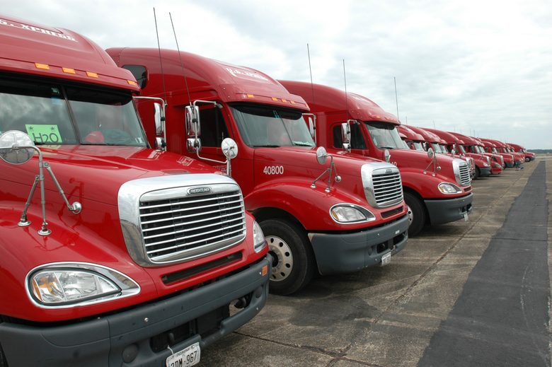 A side by side of a 1998 Mercedes-Benz ML320 and some Freightliner Columbia semi trucks showing the headlights